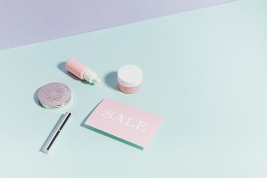 gas-pipeline Clean flat lay of pastel pink beauty products and sale card on a light background.